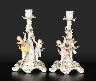 Lot 573 - Paar porseleinen kandelaars met putti
