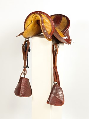 Lot 520 - Early leather saddle with leather and metal stirrups