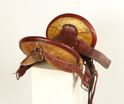 Lot 520 - Early leather saddle with leather and metal stirrups